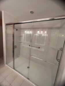 Renovated bathroom with marble flooring, glass-enclosed walk-in shower, and dark brown wood cabinets