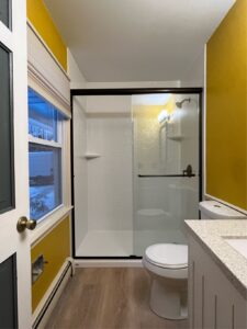 tub-to-shower conversion in a yellow bathroom 
